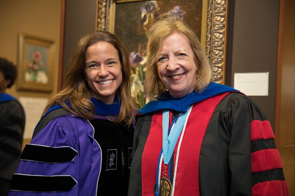 Before the Convocation, two faculty members are happily smiling for a picture.